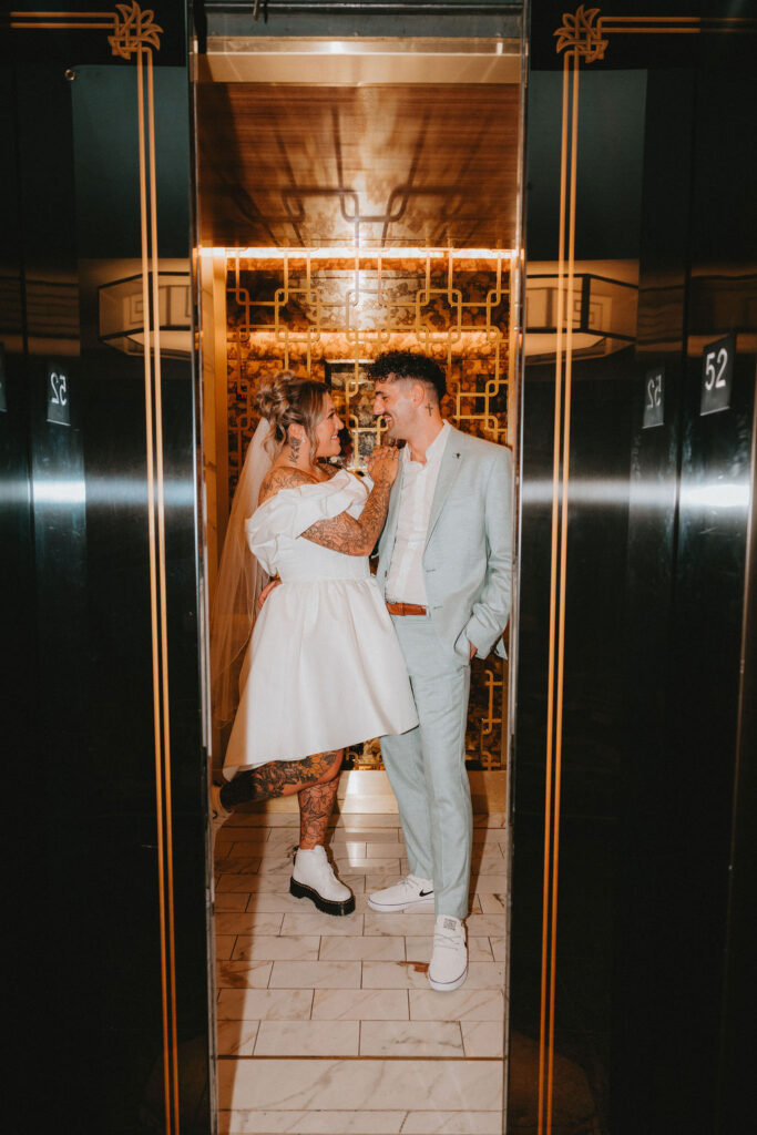 Wedding portraits in the heart of downtown Las Vegas with neon lights glowing behind the couple.
