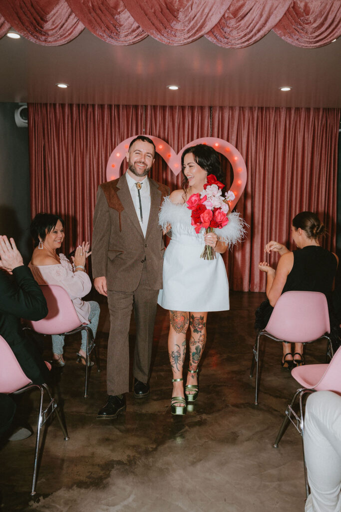 Couple celebrating their sure thing chapel elopement in Las Vegas surrounded by joyful guests.
