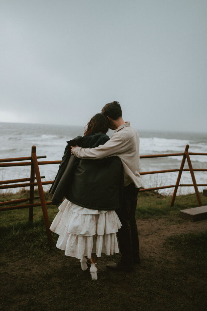 Couple walking along the Oregon Coast during a moody engagement session.
