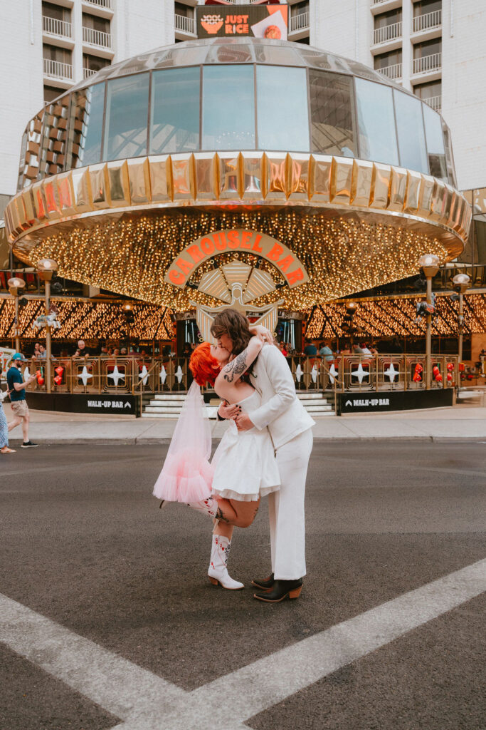 Zoe and Parker celebrating in downtown Las Vegas with neon lights glowing behind them.
