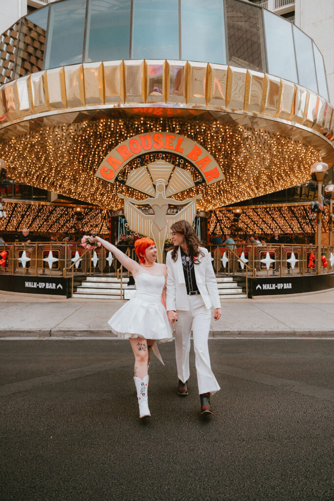 Zoe and Parker celebrating in downtown Las Vegas with neon lights glowing behind them.
