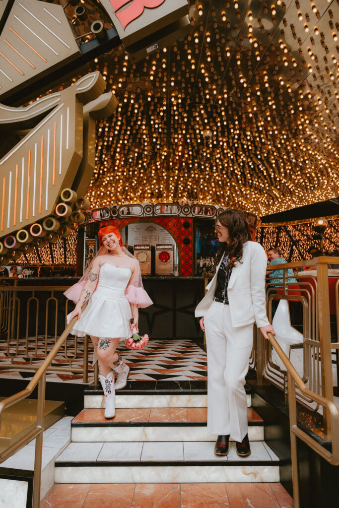 Zoe and Parker celebrating in downtown Las Vegas with neon lights glowing behind them.

