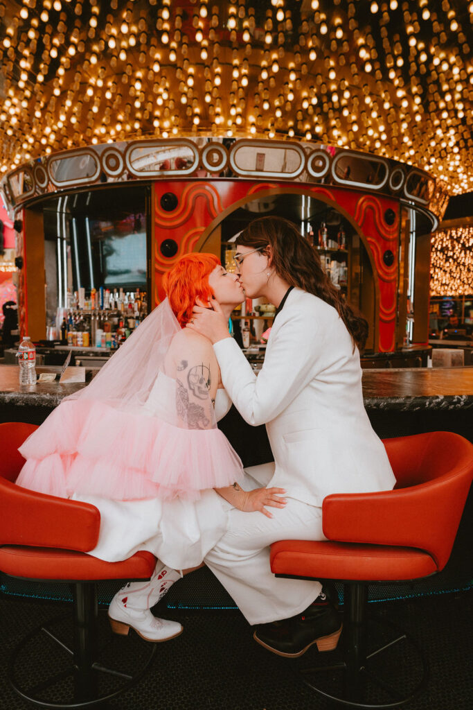 Zoe and Parker celebrating in downtown Las Vegas with neon lights glowing behind them.
