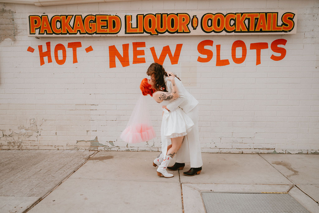 Zoe and Parker celebrating in downtown Las Vegas with neon lights glowing behind them.