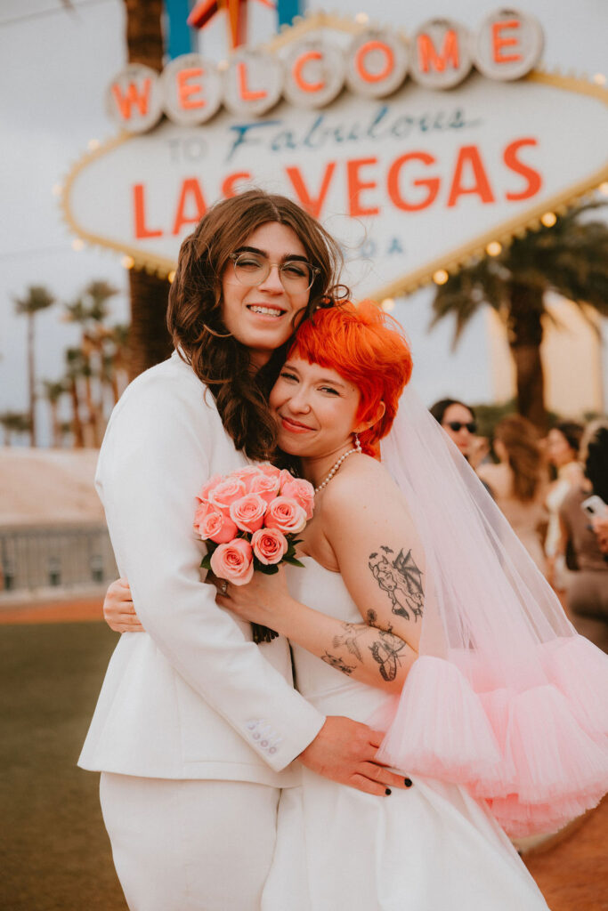 Zoe and Parker celebrating in downtown Las Vegas with neon lights glowing behind them.
