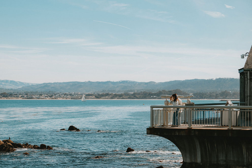 Couple on a pier during their cinematic engagement photos at Monterey Bay Aquarium