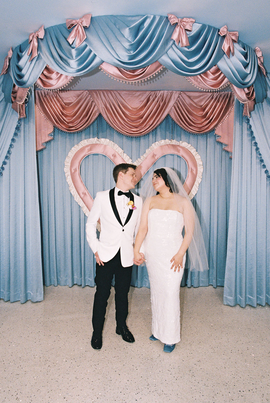 Couple holds hands at their playful Las Vegas elopement ceremony at Sure Thing Too