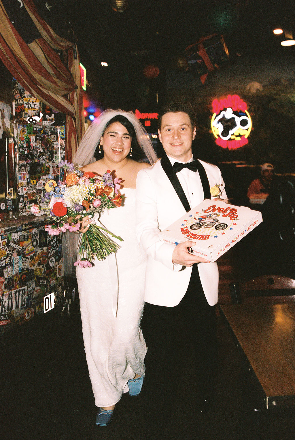 Couple with pizza box at their playful Las Vegas elopement