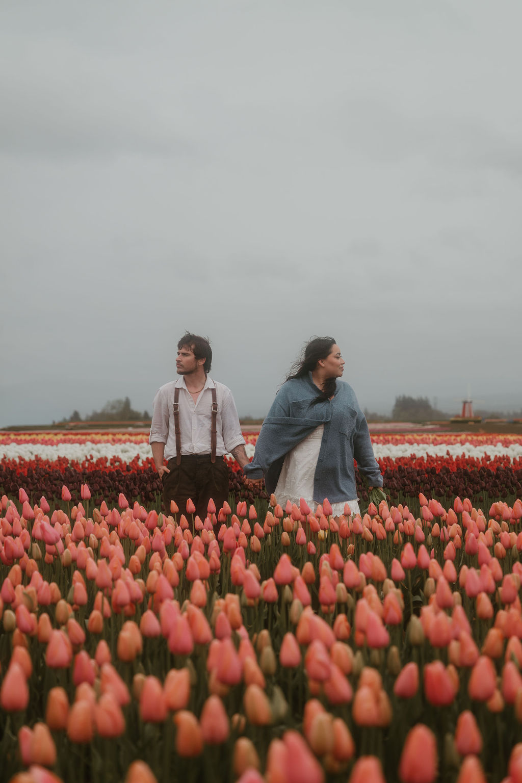 Couple holds hands at Wooden Shoe Tulip Farm engagement photos